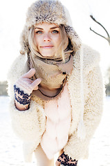 Image showing young pretty teenage hipster girl outdoor in winter snow park having fun drinking coffee, warming up happy smiling, lifestyle people concept