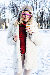 Image showing young pretty teenage hipster girl outdoor in winter snow park having fun drinking coffee, warming up happy smiling, lifestyle people concept