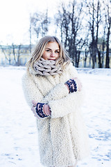 Image showing young pretty teenage hipster girl outdoor in winter snow park having fun drinking coffee, warming up happy smiling, lifestyle people concept