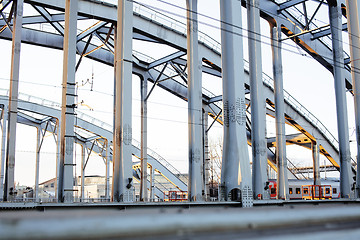 Image showing landscape with railway with trains, lot of steel rafters at sunset