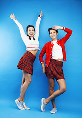 Image showing best friends teenage school girls together having fun, posing emotional on blue background, besties happy smiling, lifestyle people concept 