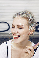 Image showing young pretty party girl smiling covered with glitter tinsel, fashion dress, stylish make up, lifestyle people concept close up