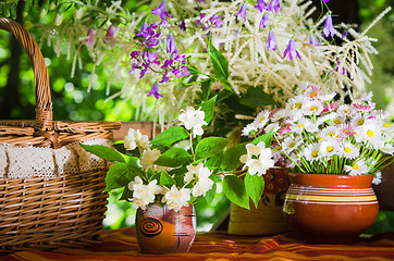 Image showing Buns in a wicker basket and a bouquet of flowers