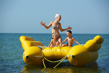 Image showing two children with mom on the dinghy sailing at sea in summer