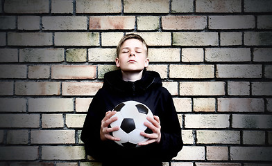 Image showing A boy against a wall with a ball