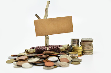 Image showing Paper sign board with stack of coins