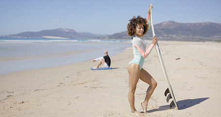 Image showing Female posing with surfboard on beach