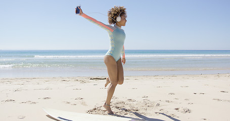 Image showing Female listening to music on beach