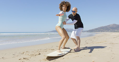 Image showing Man teaching woman standing on surf