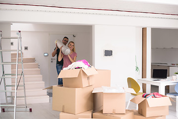 Image showing couple carrying a carpet moving in to new home