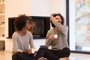 Image showing multiethnic couple  in front of fireplace