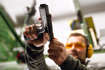 Image showing Shooting a gun at a shooting range.