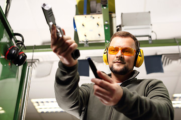 Image showing Shooting a gun at a shooting range.