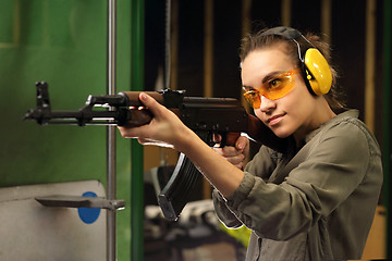 Image showing Woman in vest shot at the shooting range with a rifle