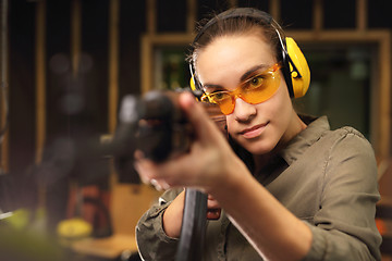 Image showing The woman at the shooting range. Woman shoots a rifle at the shooting range