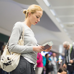 Image showing Casual woman waiting for her flight at airport.