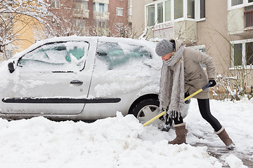 Image showing Independent woman shoveling snow in winter.