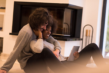 Image showing multiethnic couple used tablet computer on the floor