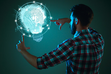 Image showing Handsome young man with idea bulb on blue