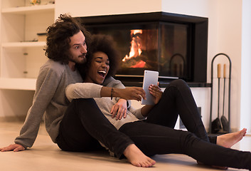 Image showing multiethnic couple used tablet computer on the floor