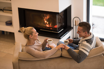 Image showing Young couple  in front of fireplace