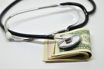 Image showing Stethoscope sitting on US dollar bills