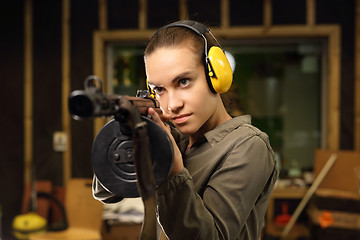 Image showing Shooting range. A woman with a machine gun.