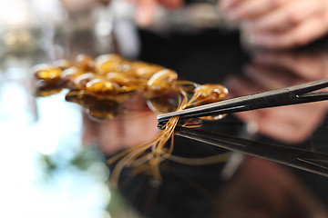 Image showing Amber jewelry Manufactory, a woman carries jewelry made of amber