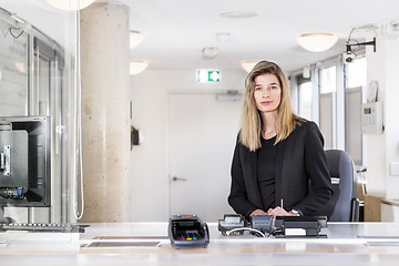 Image showing Saleswoman behind a ticket counter