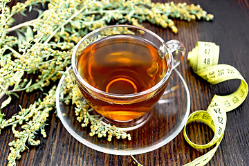 Image showing Tea with wormwood in glass cup and meter on board