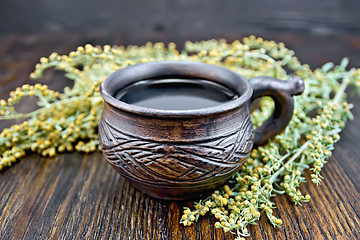 Image showing Tea with wormwood in cup on board