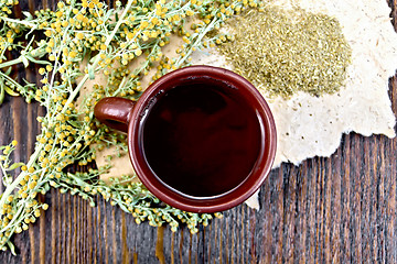 Image showing Tea with wormwood in clay cup on board top