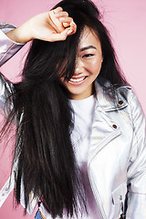 Image showing young pretty smiling asian korean girl wearing modern fashion clothers on pink background, lifestyle people concept