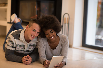 Image showing multiethnic couple used tablet computer on the floor