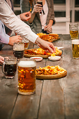 Image showing Group of friends enjoying evening drinks with beer