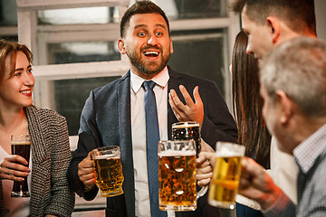 Image showing Group of friends enjoying evening drinks with beer