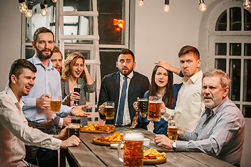 Image showing Group of friends enjoying evening drinks with beer