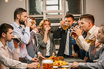 Image showing Group of friends enjoying evening drinks with beer