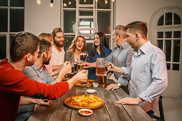 Image showing Group of friends enjoying evening drinks with beer