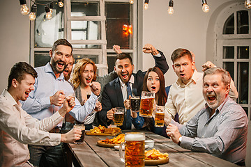 Image showing Group of friends enjoying evening drinks with beer