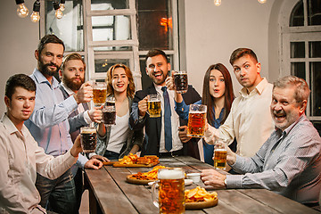 Image showing Group of friends enjoying evening drinks with beer