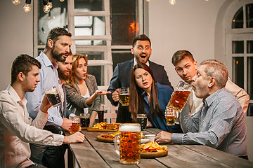 Image showing Group of friends enjoying evening drinks with beer