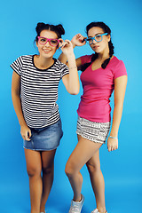 Image showing best friends teenage school girls together having fun, posing emotional on blue background, besties happy smiling, lifestyle people concept 