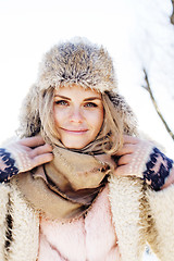 Image showing young pretty teenage hipster girl outdoor in winter snow park having fun drinking coffee, warming up happy smiling, lifestyle people concept