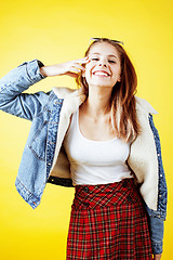 Image showing young pretty teenage hipster girl posing emotional happy smiling on yellow background, lifestyle people concept