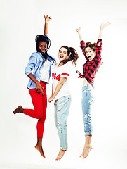 Image showing three pretty young diverse nations teenage girl friends jumping happy smiling on white background, lifestyle people concept 