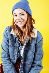 Image showing young pretty teenage hipster girl posing emotional happy smiling on yellow background, lifestyle people concept