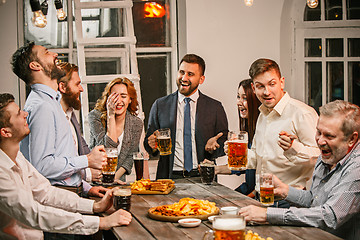 Image showing Group of friends enjoying evening drinks with beer