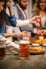 Image showing Group of friends enjoying evening drinks with beer