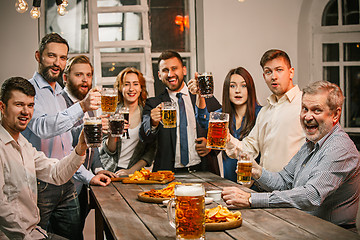 Image showing Group of friends enjoying evening drinks with beer